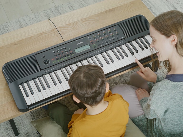 Parent and child happily playing the YPT-280 side by side