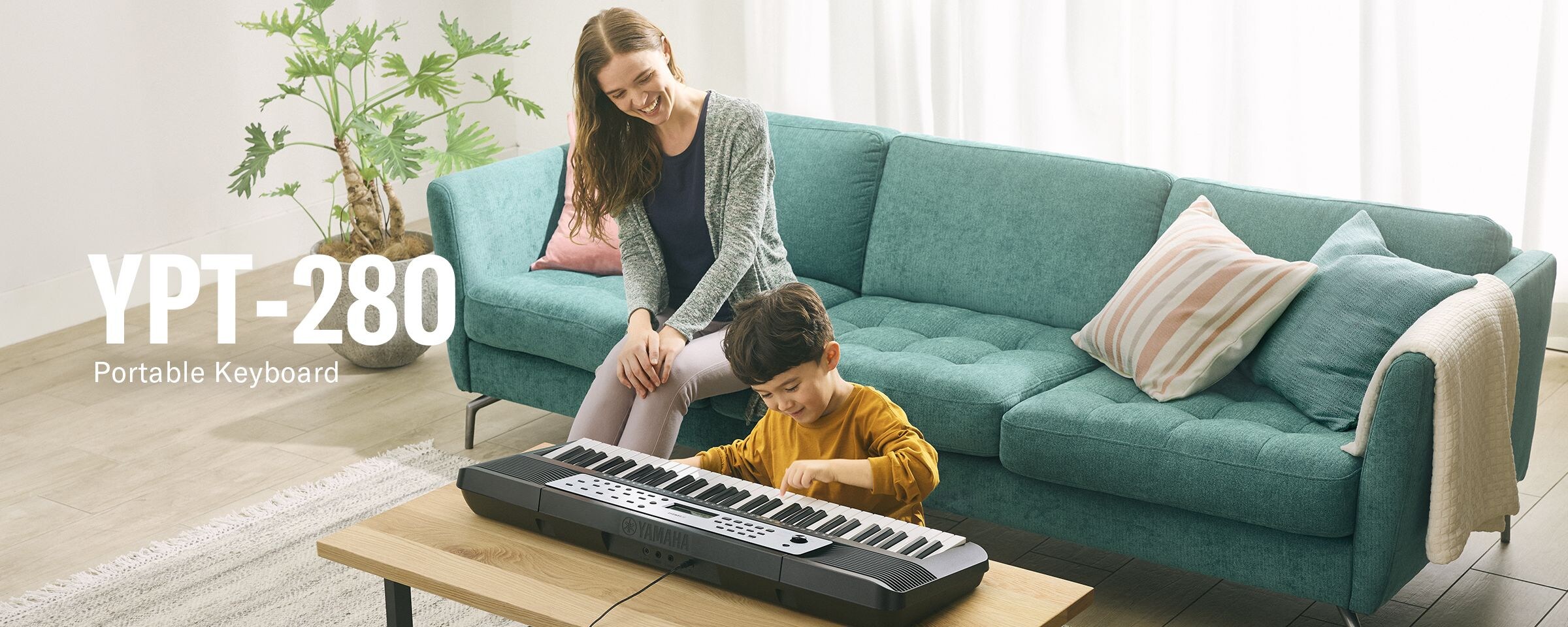 Parent and child happily playing the YPT-280 on the table