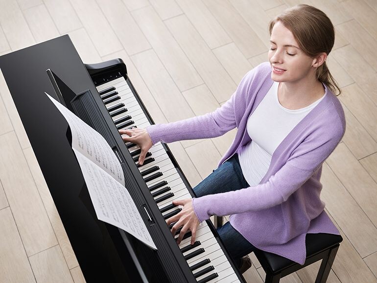 A person playing Yamaha Clavinova CLP-875PE with a pleasant feeling