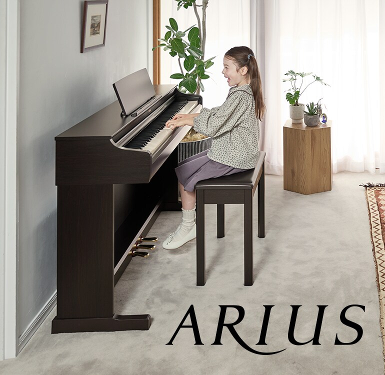 Una niña tocando un piano digital ARIUS en casa, demostrando una musicalidad en constante crecimiento y una expresión emocional más profunda.