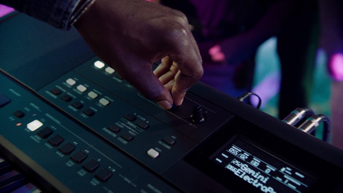 Una persona controlando la perilla Live Control del PSR-E483