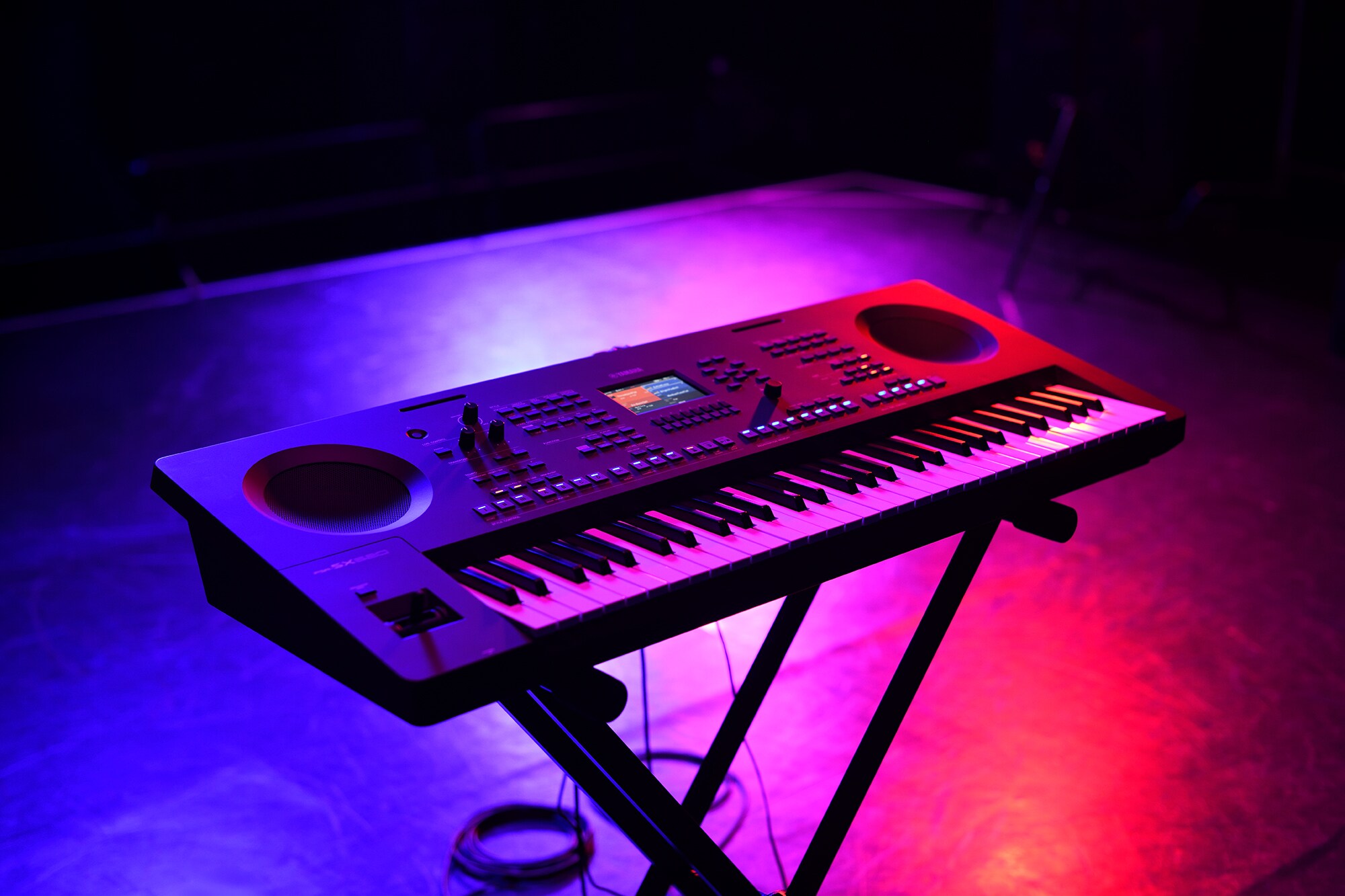 Un teclado en un soporte bajo la iluminación del escenario