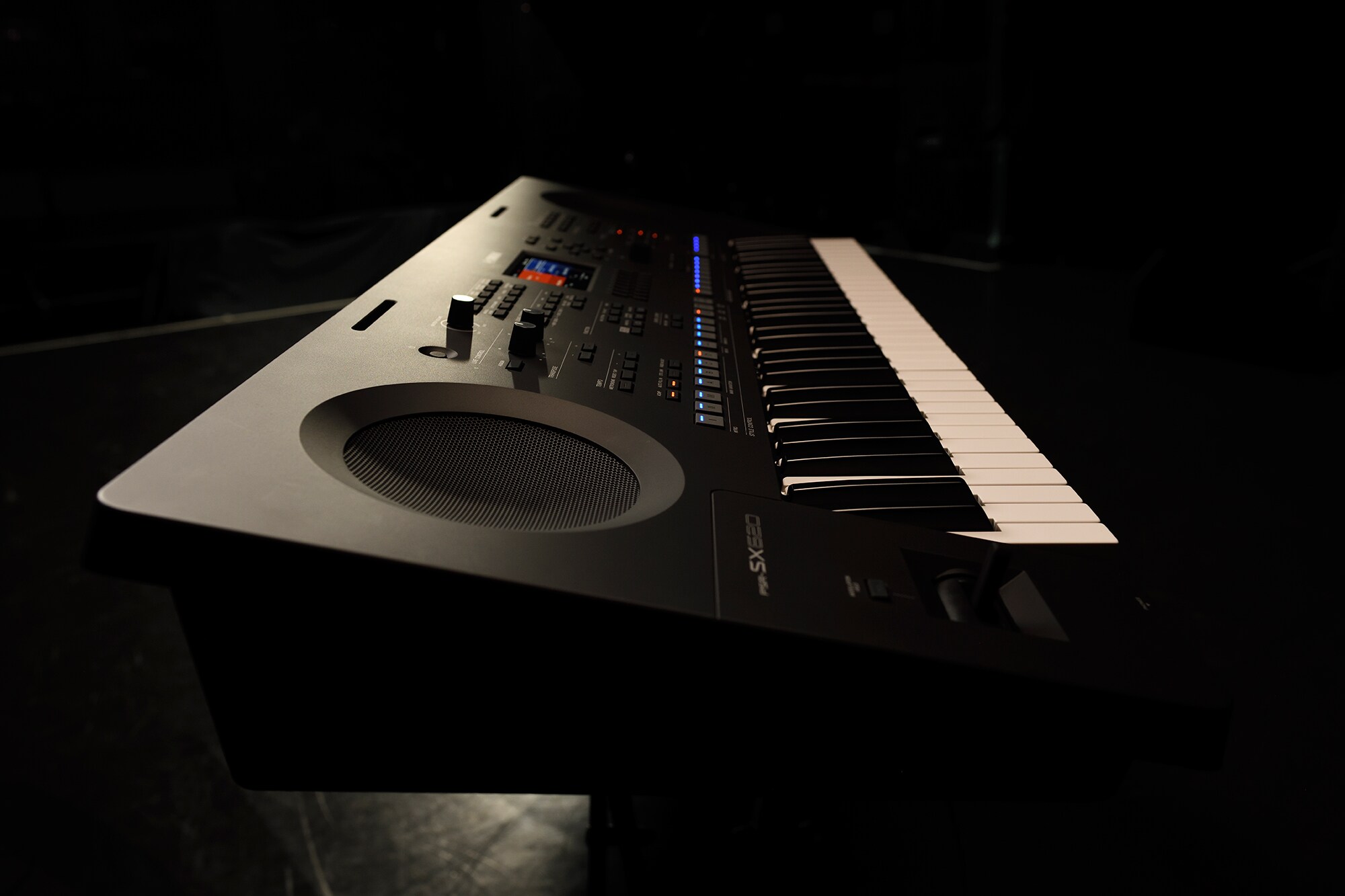 Un teclado en un soporte bajo la iluminación del escenario