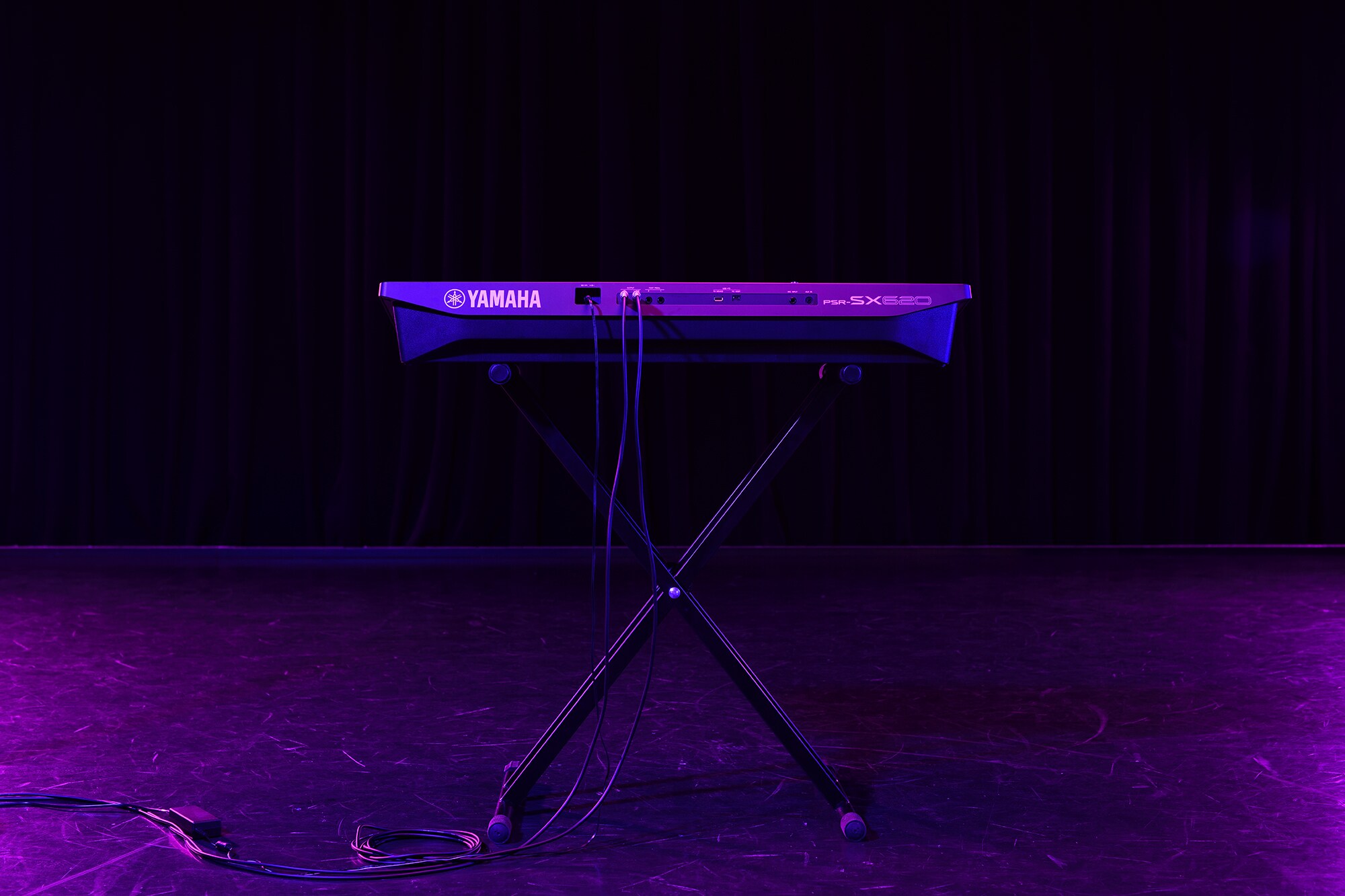 Un teclado en un soporte bajo la iluminación del escenario
