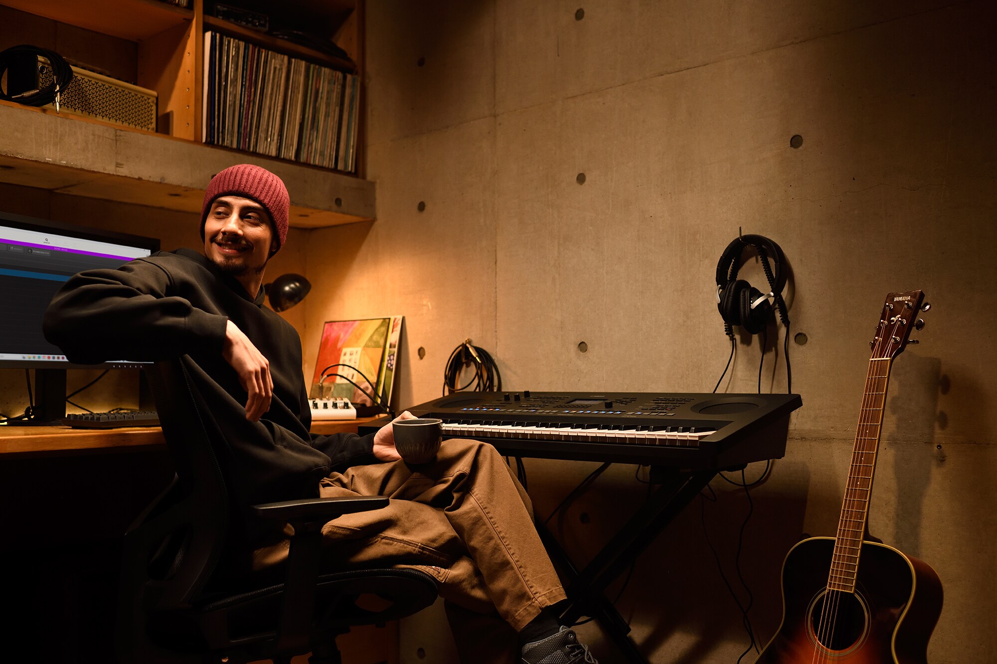Un espacio de trabajo musical en casa con una computadora y un teclado, que muestra a un tecladista trabajando en su home studio