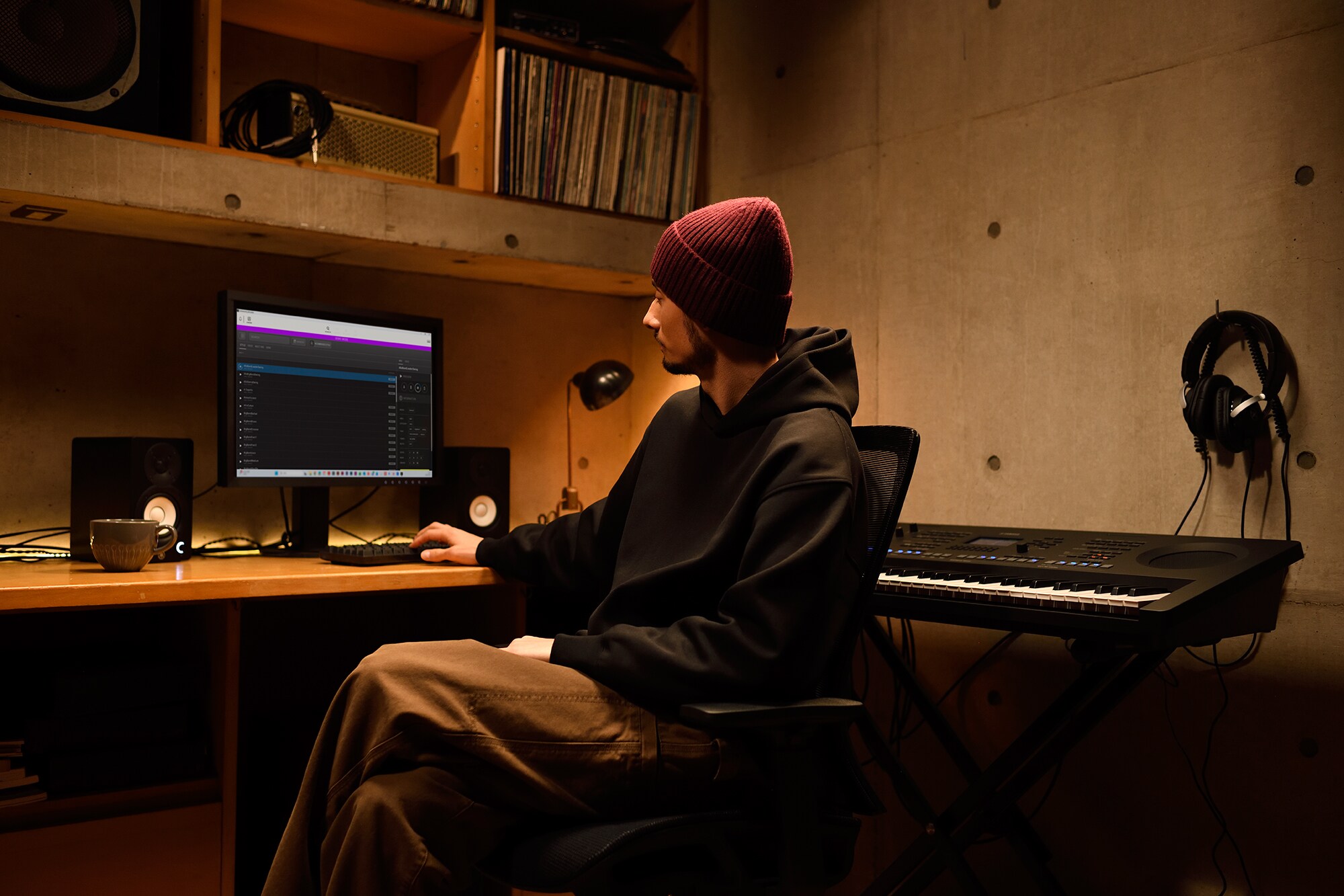 Un espacio de trabajo musical en casa con una computadora y un teclado, que muestra a un tecladista trabajando en su home studio