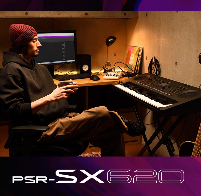 Persona sentada frente a un teclado PSR-SX en un home studio, bebiendo café.