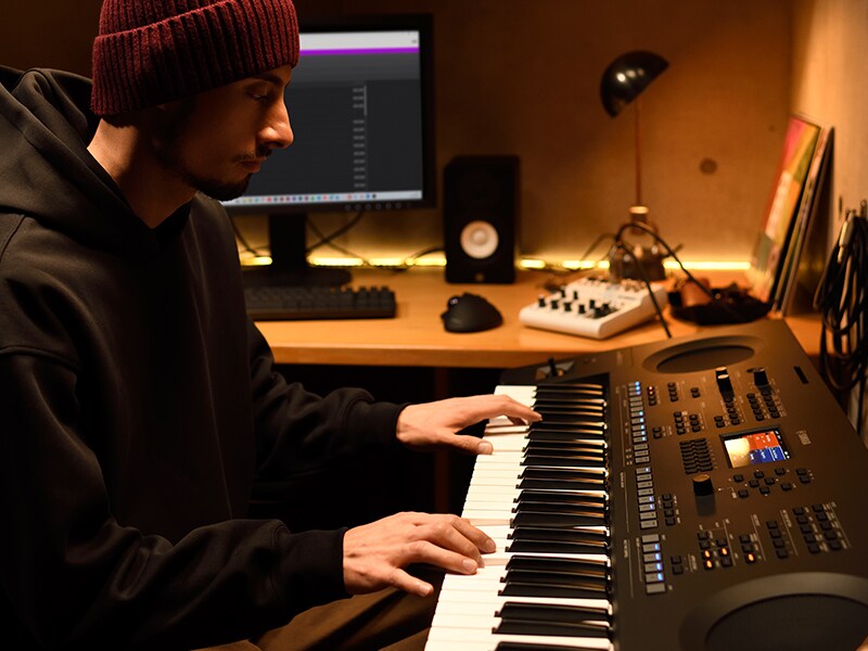 Músico tocando un teclado PSR-SX620 en un home studio.