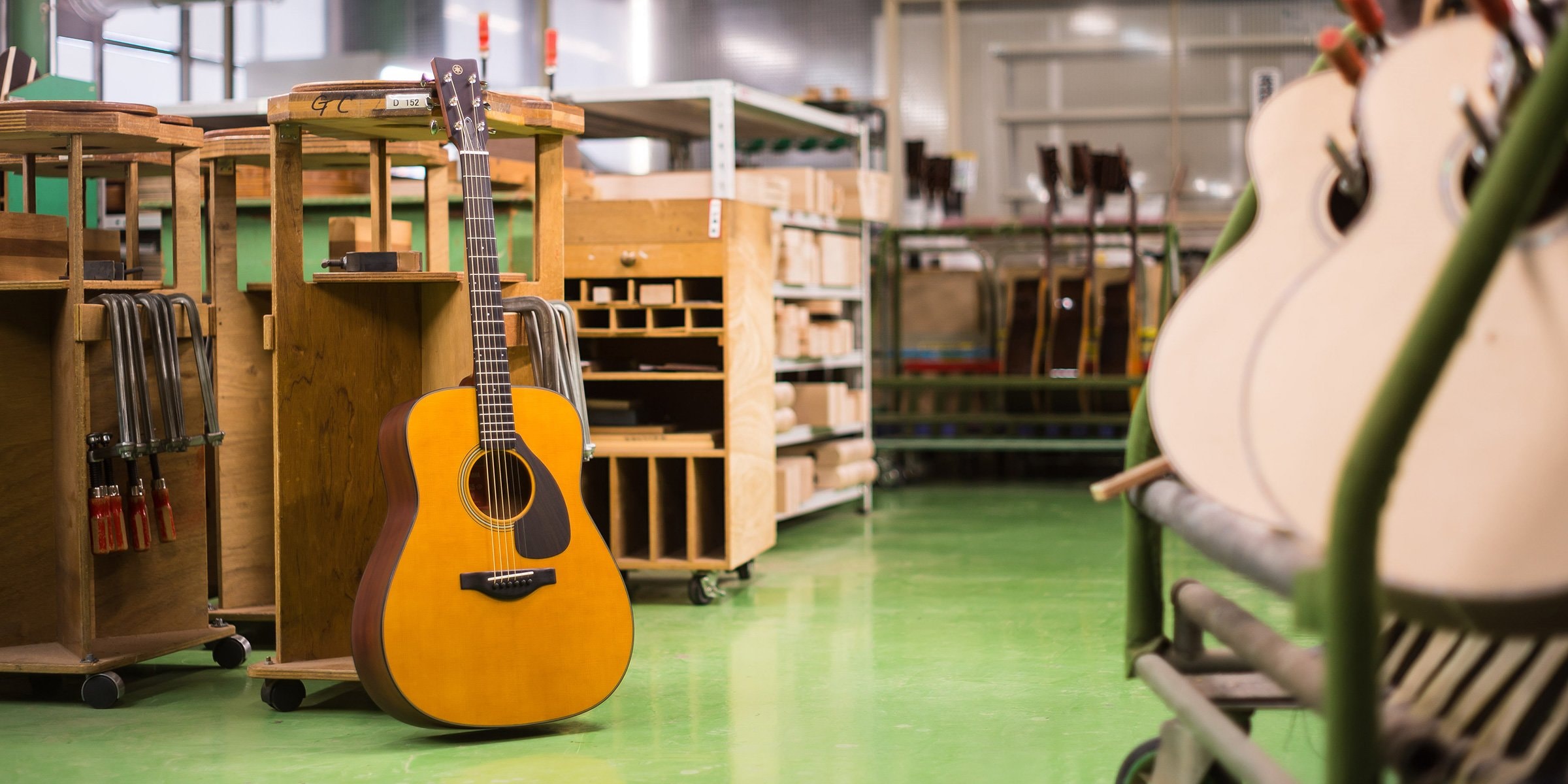 Una guitarra FG5 de frente se apoya contra la mesa de trabajo en la tienda Custom Shop.