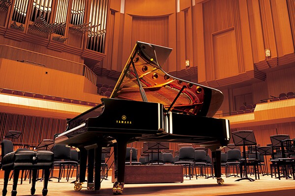 Piano de cola de concierto Yamaha CFX en el escenario de una sala de conciertos