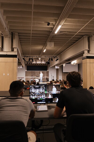 Voluntarios de la iglesia participando en la capacitación del sistema de audio junto a los racks de equipos y sistemas de producción.