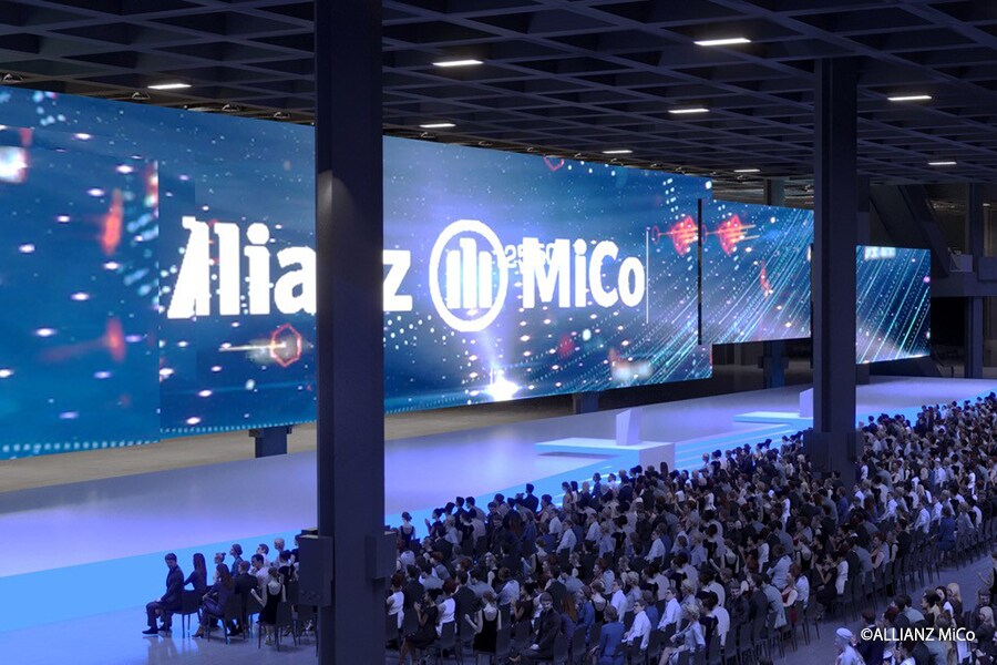 Vista panorámica de un evento a gran escala en Allianz MiCo que muestra una enorme pantalla LED y la zona de asientos para el público dentro del centro de congresos.